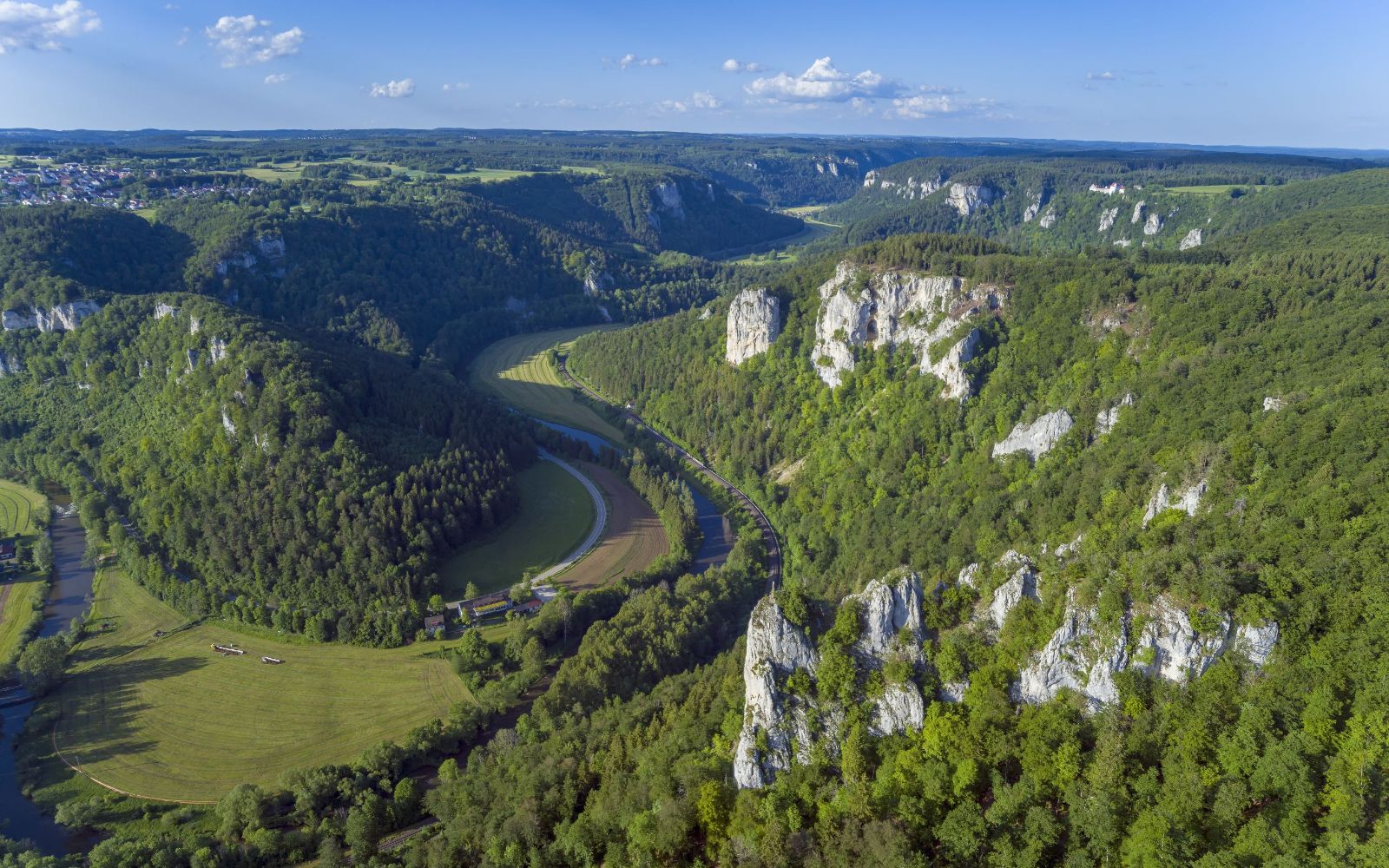 Picture with a view from above of several rocks, hills and fields in the Donaubergland