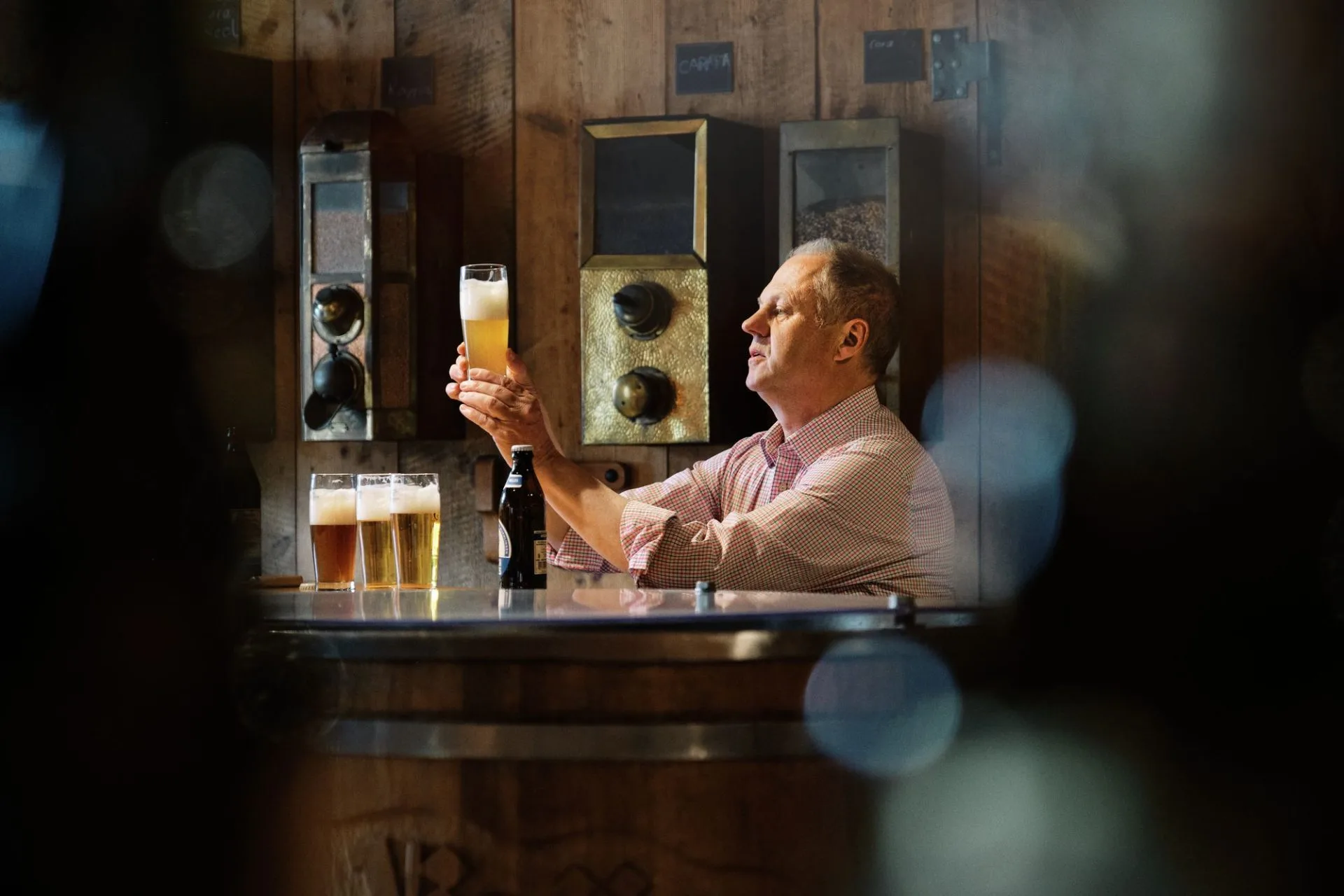 Picture of a master brewer who has several glasses in front of him during the beer tasting and is looking at the contents