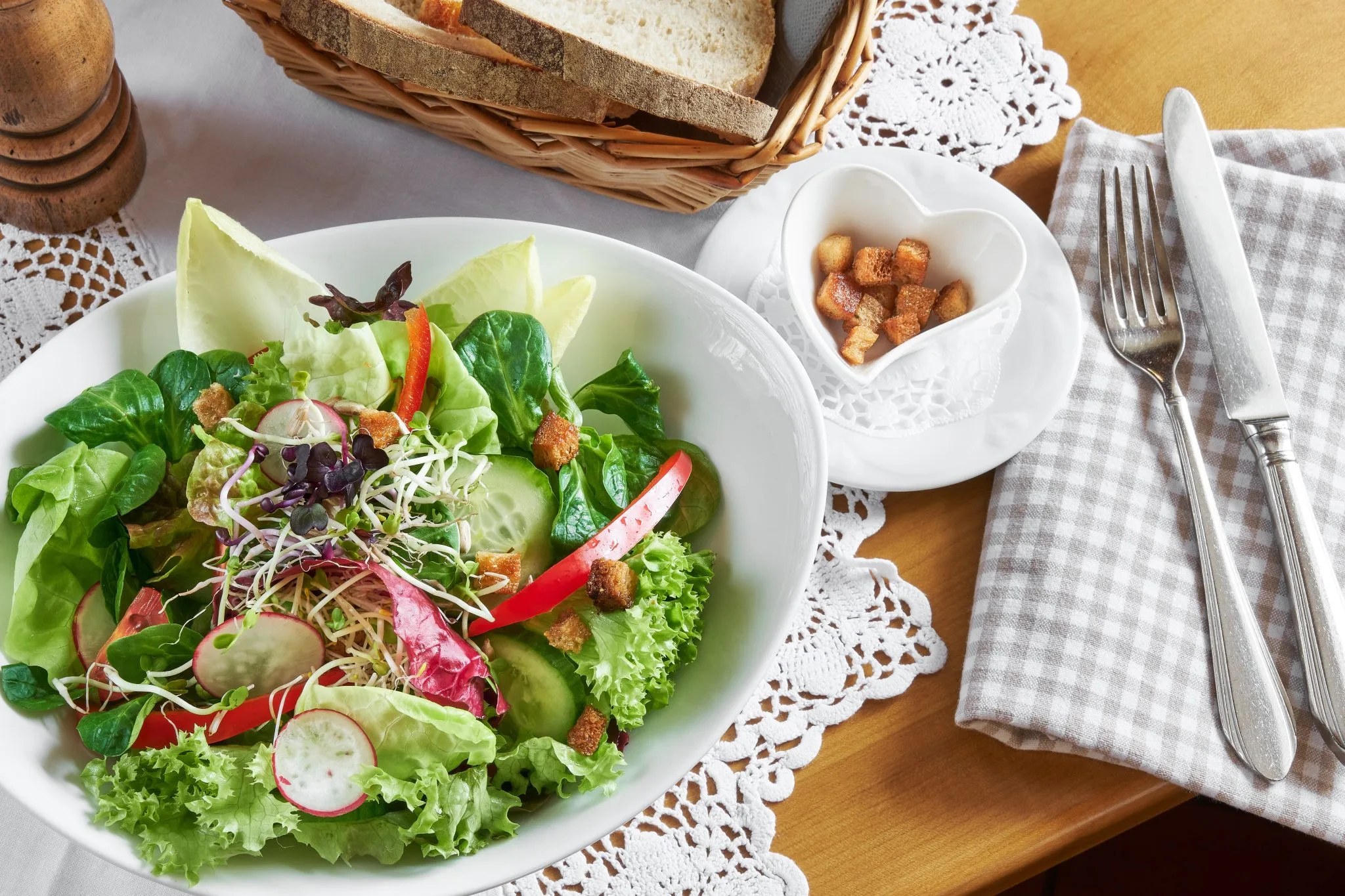 Bild von Salatteller und Brot im Korb und Besteck