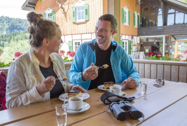 Bild von zwei Personen, die am Gasthaus Jägerhaus jeweils eine Donauwelle, einen Kaffee und ein Glas Wasser vor sich stehen haben