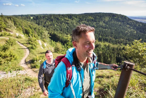 Zwei Männer mit Rucksack auf Wanderweg im Mittelgebirge